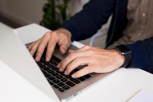 Close-up of individual using laptop to calculate child support payments