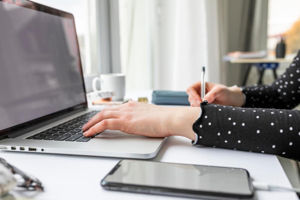 Side view woman working on laptop